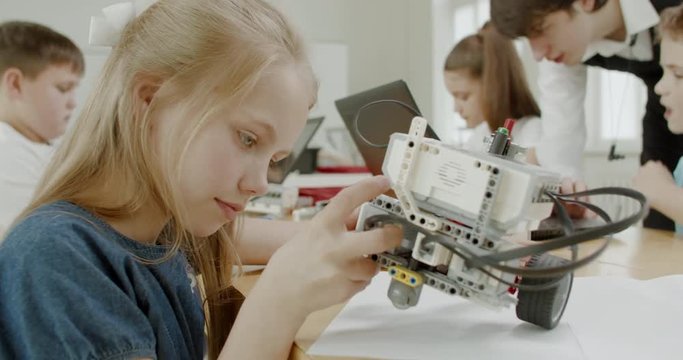 Curious kids working on a functional programable robot during robotics class at school. 4K UHD 60 FPS SLOW MOTION