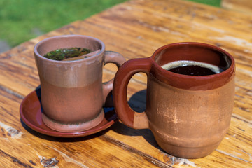 two clay mugs with a drink inside