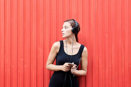 Beautiful girl in headphones over red background.