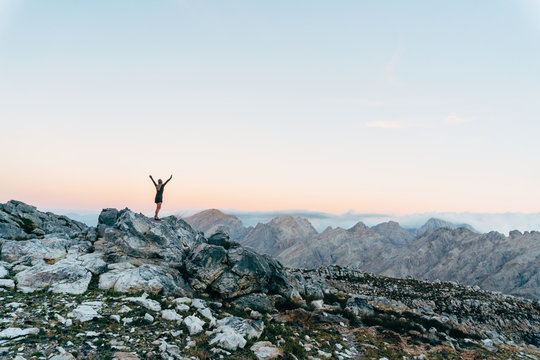 Hiker on mountain summit at sunset