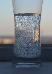 glass of water with bubbles on blue background