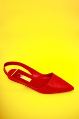 Red woman shoes isolated on the yellow background.