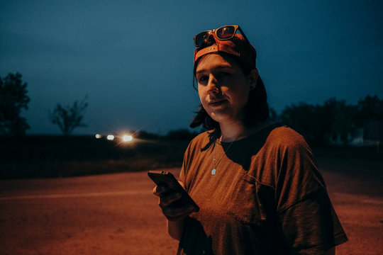 Tomboy female model standing on the road at night