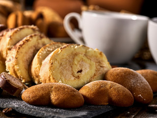 Cookies heart shape, sand rolled biscuit and cinnamon stick on wood table served dessert spoon at kitchen in rustic style. Morning sun flare. Traditional dish.