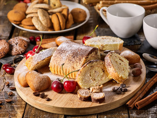 Cookies heart shape, sand rolled biscuit and cinnamon stick on wood table served dessert spoon at kitchen in rustic style. Morning sun flare. Perfect product is traditional dish.