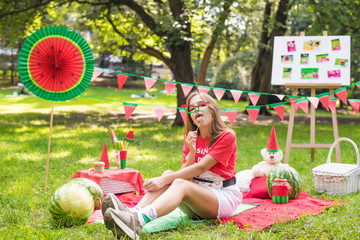 Nice teen girl having fun watermelon party In the park. Excellent sunny weather. Summer concept. Watermelon party, picnic, day. Nice teen girl having fun watermelon party In park yellow sunglasses