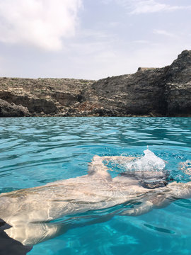 Unrecognizable guy breathing underwater.