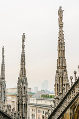 Fototapeta na wymiar Ornately carved stonework on the roof of the Duomo Milano (Milan Cathedral), Italy