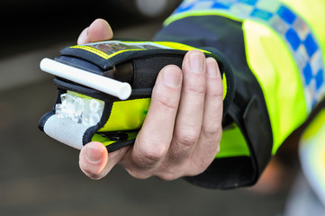 Belfast, Northern Ireland. 24 Nov 2016 - A police officer holds a roadside breathalyser alcohol...