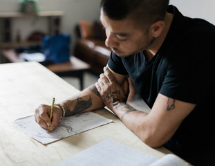male designer drawing in book