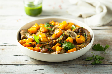 Beef on the bone with pumpkin and pesto