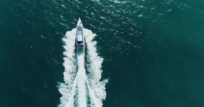 Aerial bird eye shot fast moving passenger speed boat on blue sea 4K