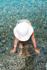 little girl in swimsuit and white hat in the sea. Summer vacation in Aegean Sea, Kos Island Greece
