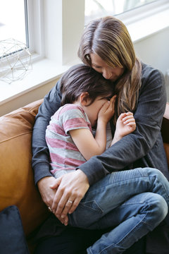 Mother and son snuggling together on couch