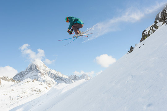 Male skier jumping from cliffs