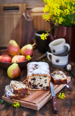 Delicious homemade chocolate and pears loaf cake on rustic wooden background