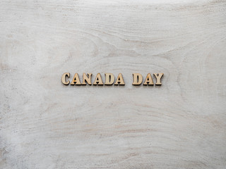 CANADA DAY. Wooden, unpainted letters on a white table. Close-up, top view. Beautiful photo with a space for your inscriptions. Congratulations to loved ones, relatives, family, friends and colleagues