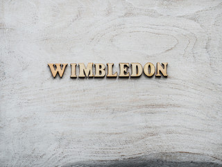 WIMBLEDON. Wooden, unpainted letters on a white table. Close-up, top view. Beautiful photo for...