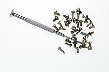 Metal small screwdriver and a few screws on a white background - 270654062