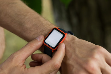 Cropped image of modern smartwatch on man's wrist for checking notification from smartphone