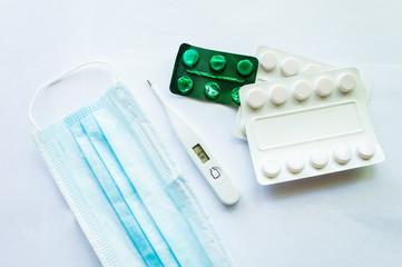 Medicaments on a white background, pills, thermometer, inhaler