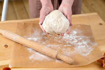 female hands rolling out dough with a rolling pin