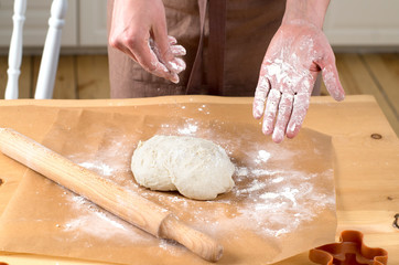 female hands rolling out dough with a rolling pin