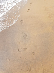 beach, wave and footprints at sun summer time