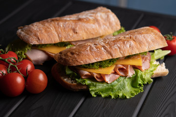 Fresh baguette. Delicious breakfast. Food. Lunch with tomatoes. Black table. Kitchen