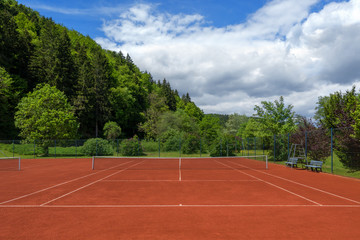 Sauber abgezogener Tennisplatz mit rotem Sand nach der Frühjahrsüberholung