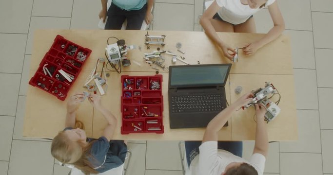 OVERHEAD Curious kids working on a functional programable robot during robotics class at school. 4K UHD 60 FPS SLOW MOTION