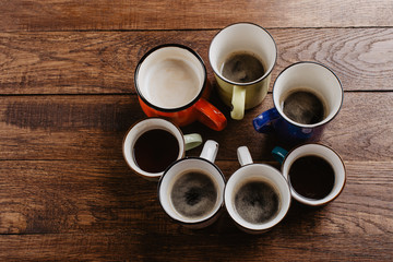 Fototapeta na wymiar various mugs of coffee, wooden table, top view