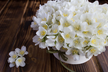 Fototapeta na wymiar White jasmine flowers in the gift box on the brown wooden background.Closeup.
