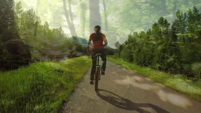 Woman Riding A Unicycle On A Forest Trail