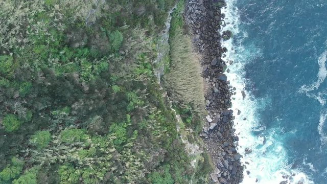 Aerial Drone water flowing over rocks along coastline