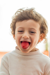 Child biting a strawberry
