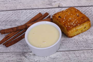 Fototapeta na wymiar Condenced milk in the bowl with sinnamon and pastry