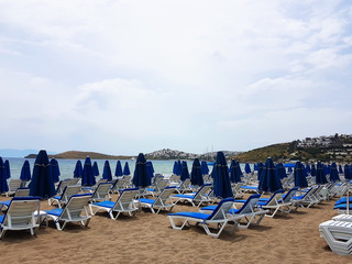 Lots of blue sunbeds with umbrellas at the sea beach