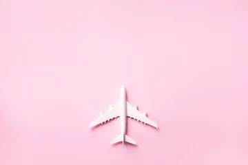 Schilderijen op glas Creative layout. Top view of white model plane, airplane toy on pink pastel background. Flat lay with copy space. Trip or travel banner © jchizhe