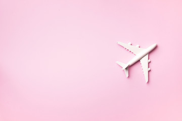 Travel, vacation concept. White model airplane on pastel pink color background with copy space. Top view. Flat lay. Minimal style design.