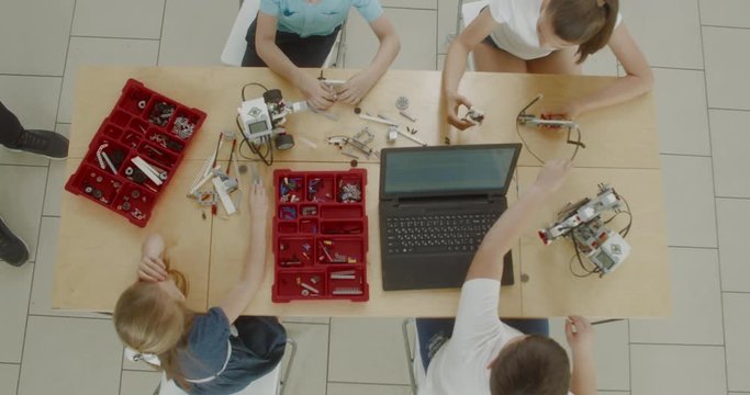 OVERHEAD Curious kids working on a functional programable robot during robotics class at school. 4K UHD 60 FPS SLOW MOTION