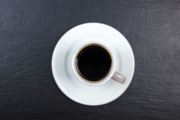 cup of coffee on black wooden background. Top view