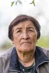 Portrait of an elderly woman in the village in the garden closeup.