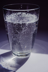 glass of water with ice and drops on white background