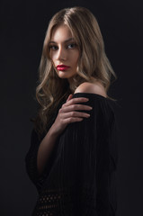 Fototapeta premium Beautiful ,young blonde with bright red lips and expressive eyes in a black jumpsuit. Beauty portrait of a girl. Emotional and bright appearance. Fashion portrait of a woman.