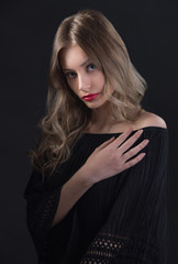 Beautiful ,young blonde with bright red lips and expressive eyes in a black jumpsuit. Beauty portrait of a girl. Emotional and bright appearance. Fashion portrait of a woman.