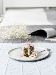 Sweet cake with poppy seeds and yogurt on a light bed.