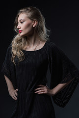 Beautiful ,young blonde with bright red lips and expressive eyes in a black jumpsuit. Beauty portrait of a girl. Emotional and bright appearance. Fashion portrait of a woman.