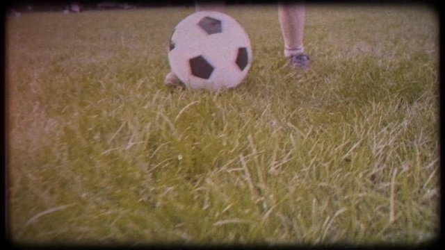 Boy playing soccer ball. Child with the ball runs through the green grass. Family video. Archived video. Old film. Famous footballer in childhood. Children's sport. Family holiday.  Training. Happy