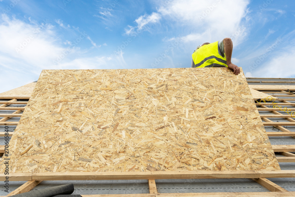 Wall mural building construction process of new wooden roof on wood frame house